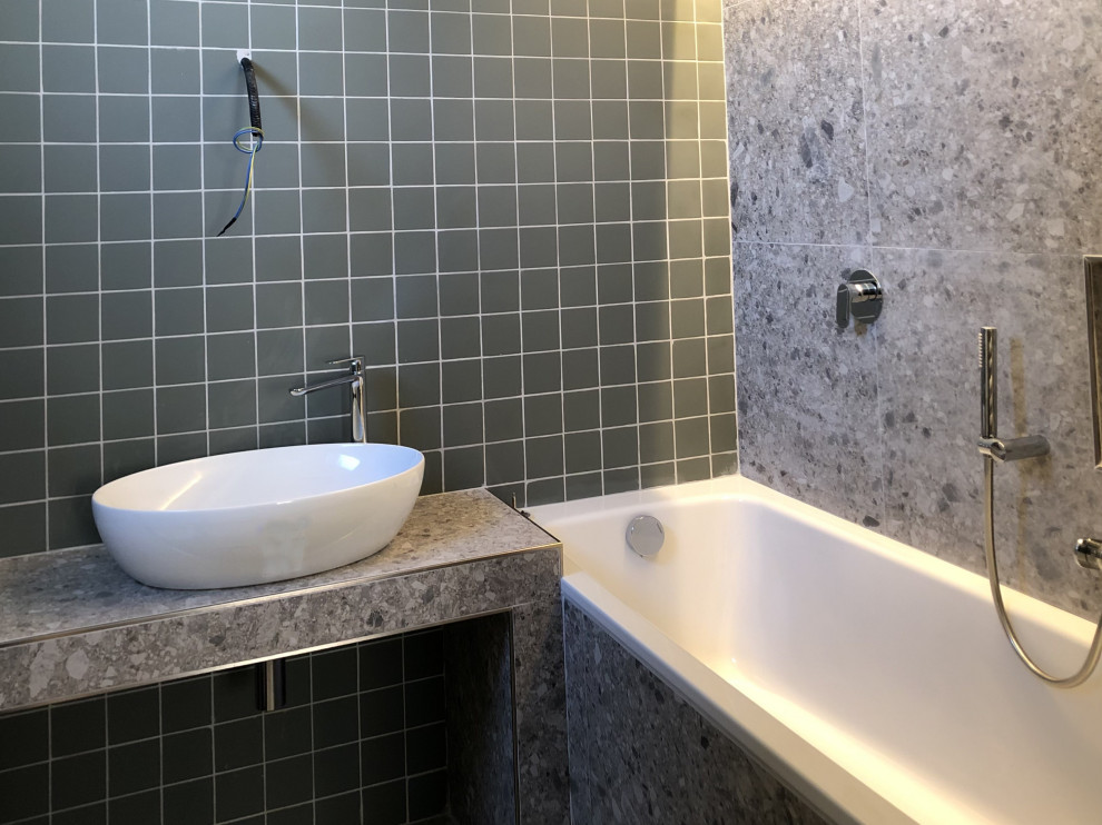 Exemple d'une salle de bain principale tendance de taille moyenne avec des portes de placard grises, une baignoire posée, WC suspendus, un carrelage vert, un sol en marbre, une vasque, un plan de toilette en marbre, un sol gris, un plan de toilette gris, meuble simple vasque et un plafond décaissé.