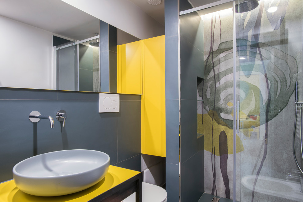 Ispirazione per una stanza da bagno con doccia contemporanea con ante gialle, WC sospeso, lavabo a bacinella, porta doccia scorrevole, top giallo e pareti grigie