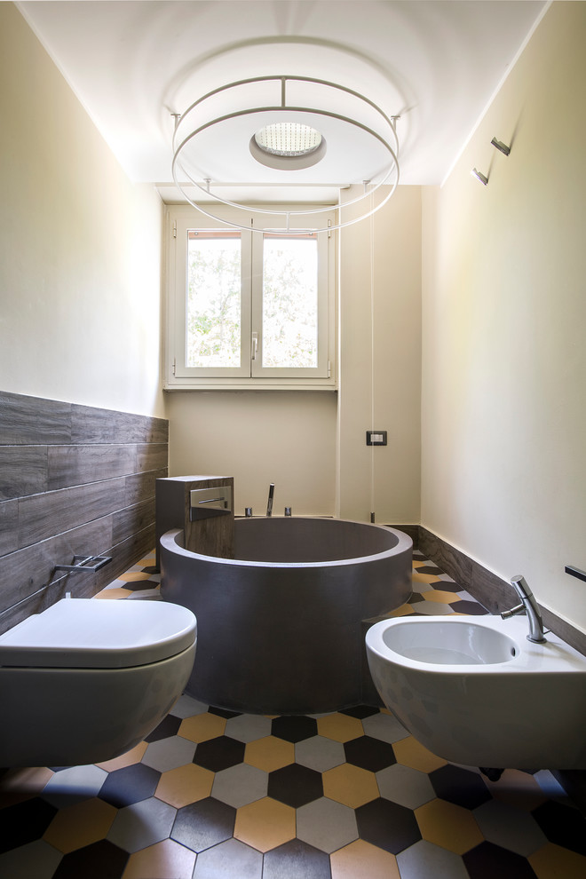 Inspiration för mellanstora moderna en-suite badrum, med en bidé, keramikplattor, gula väggar, klinkergolv i keramik, flerfärgat golv, ett fristående badkar och brun kakel