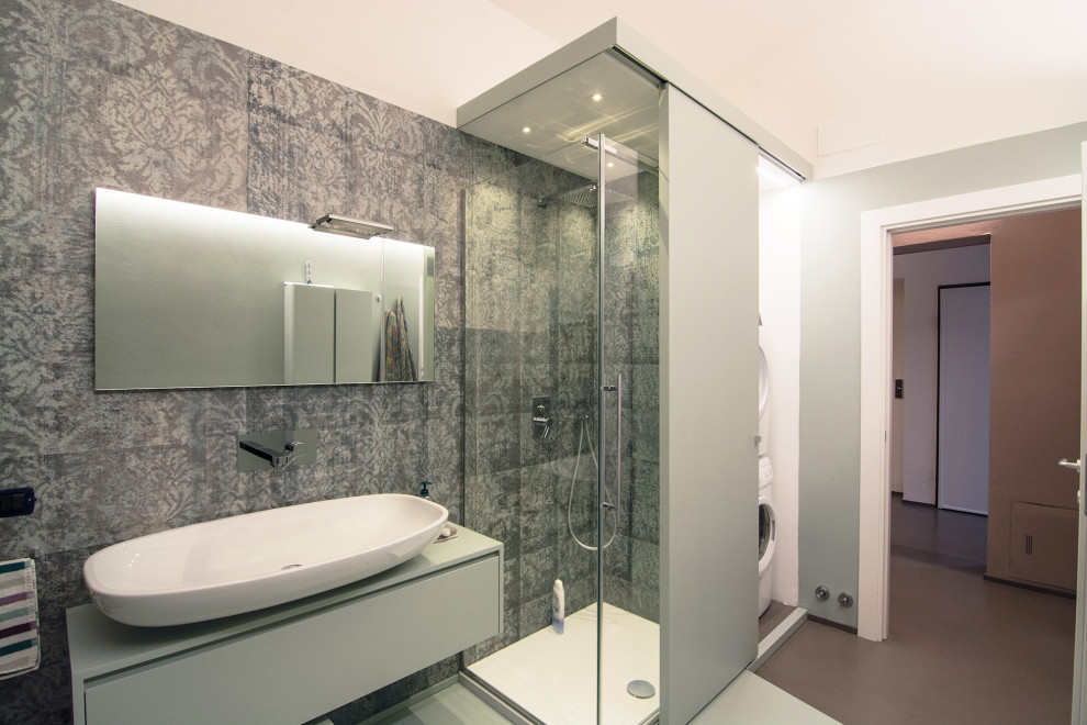Photo of a large contemporary shower room bathroom in Florence with flat-panel cabinets, green cabinets, a corner shower, a two-piece toilet, multi-coloured tiles, green walls, concrete flooring, a vessel sink, wooden worktops, green floors, a sliding door, turquoise worktops, a laundry area, a single sink, a floating vanity unit and wallpapered walls.