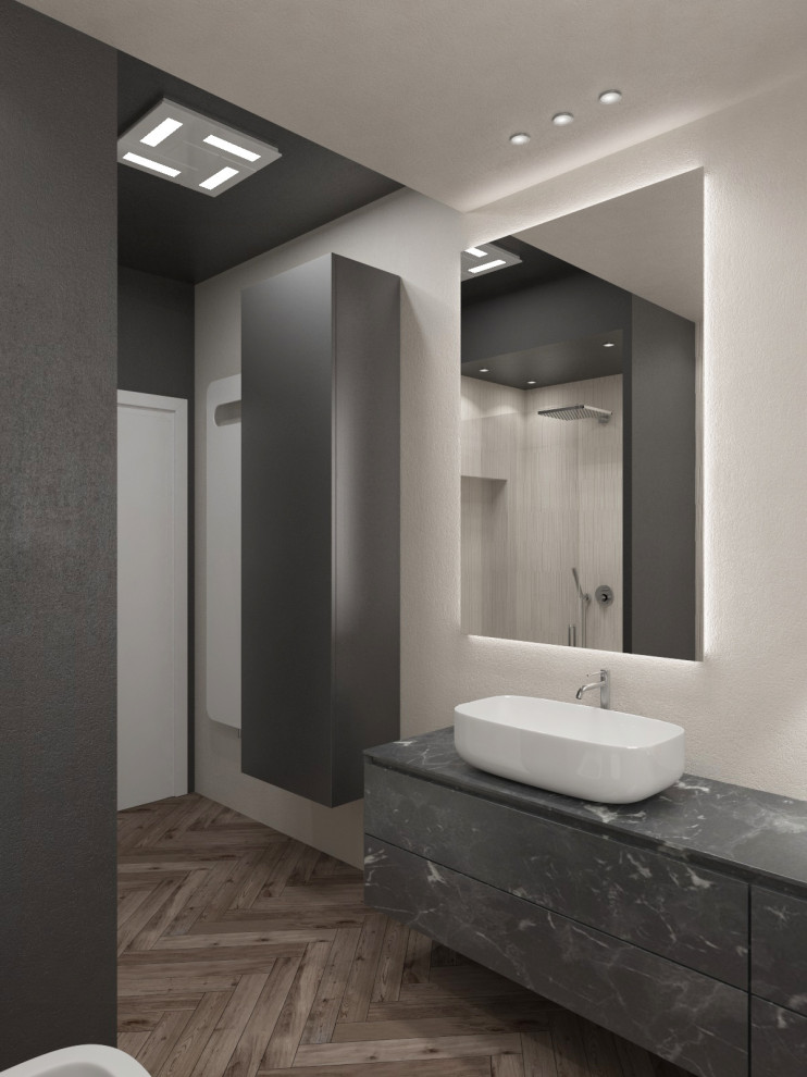 Mid-sized minimalist 3/4 beige tile and porcelain tile medium tone wood floor, brown floor, tray ceiling and single-sink bathroom photo in Venice with flat-panel cabinets, black cabinets, a two-piece toilet, gray walls, a vessel sink, black countertops, a floating vanity and a niche