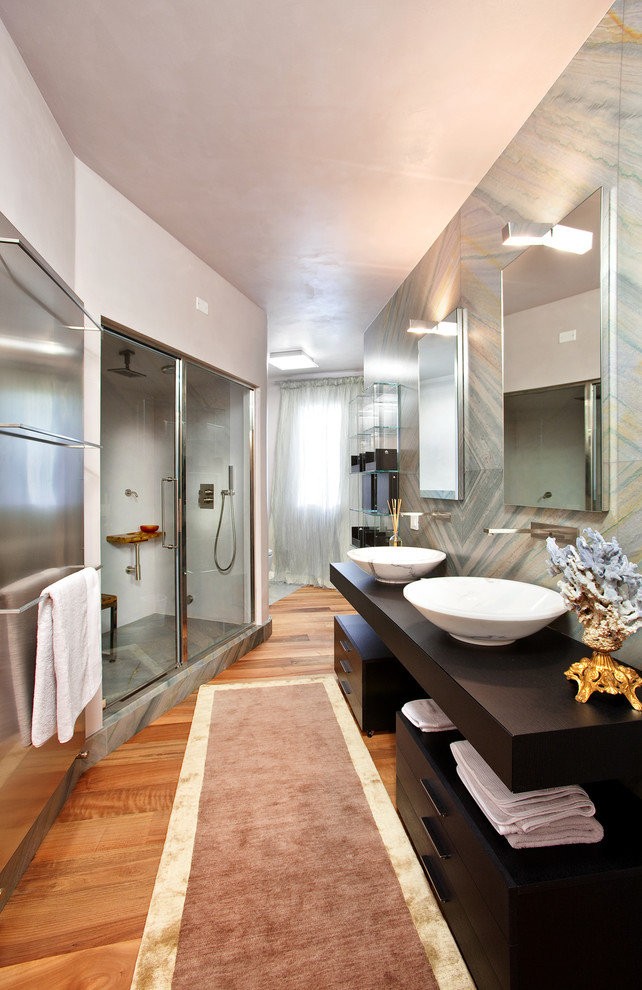 Exempel på ett stort modernt brun brunt badrum med dusch, med släta luckor, skåp i mörkt trä, en dusch i en alkov, stenhäll, vita väggar, mellanmörkt trägolv, ett fristående handfat, träbänkskiva och dusch med skjutdörr