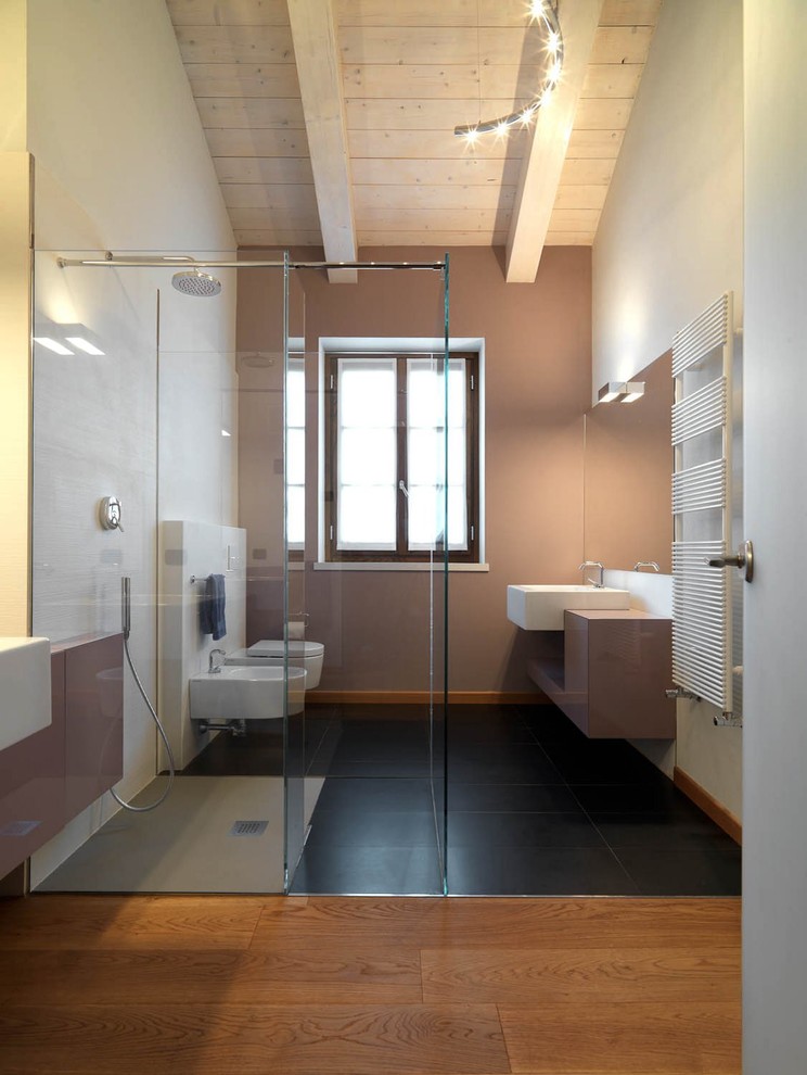 Bathroom - huge contemporary 3/4 porcelain tile and multicolored tile porcelain tile and black floor bathroom idea in Turin with flat-panel cabinets, brown cabinets, a wall-mount toilet, multicolored walls, a trough sink and glass countertops