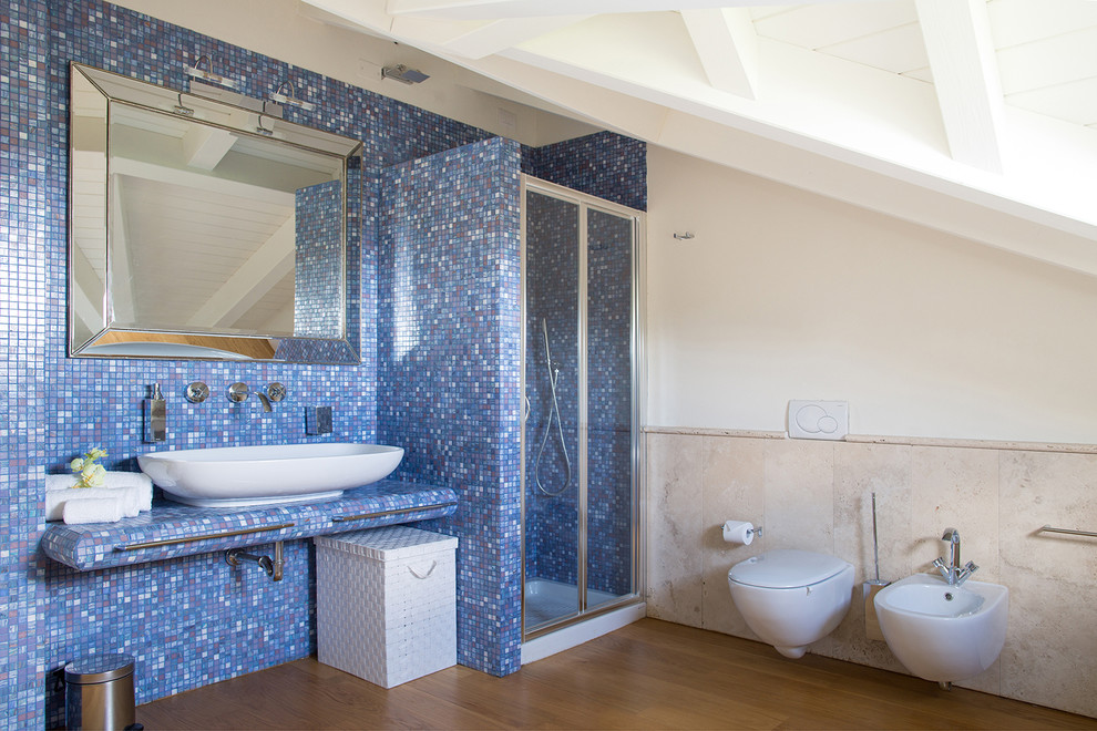 Réalisation d'une petite salle d'eau design avec une douche d'angle, un bidet, des carreaux de porcelaine, un mur bleu, parquet foncé, une vasque, un sol marron et une cabine de douche à porte coulissante.
