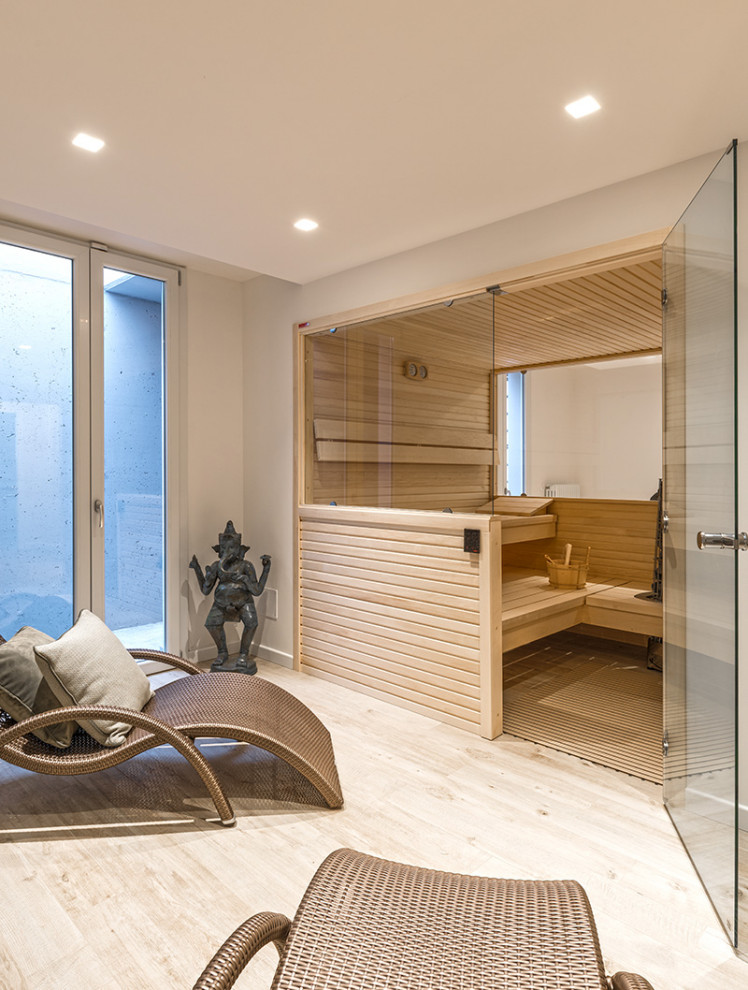 Foto de sauna marinera de tamaño medio con paredes blancas, suelo de madera clara y bandeja
