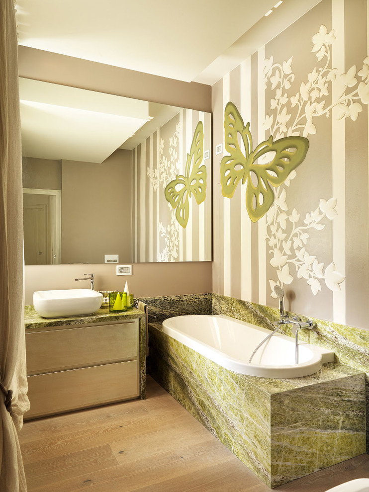 Foto di una stanza da bagno contemporanea con ante lisce, ante in legno chiaro, vasca da incasso, lavabo a bacinella, top in marmo e pavimento in legno massello medio