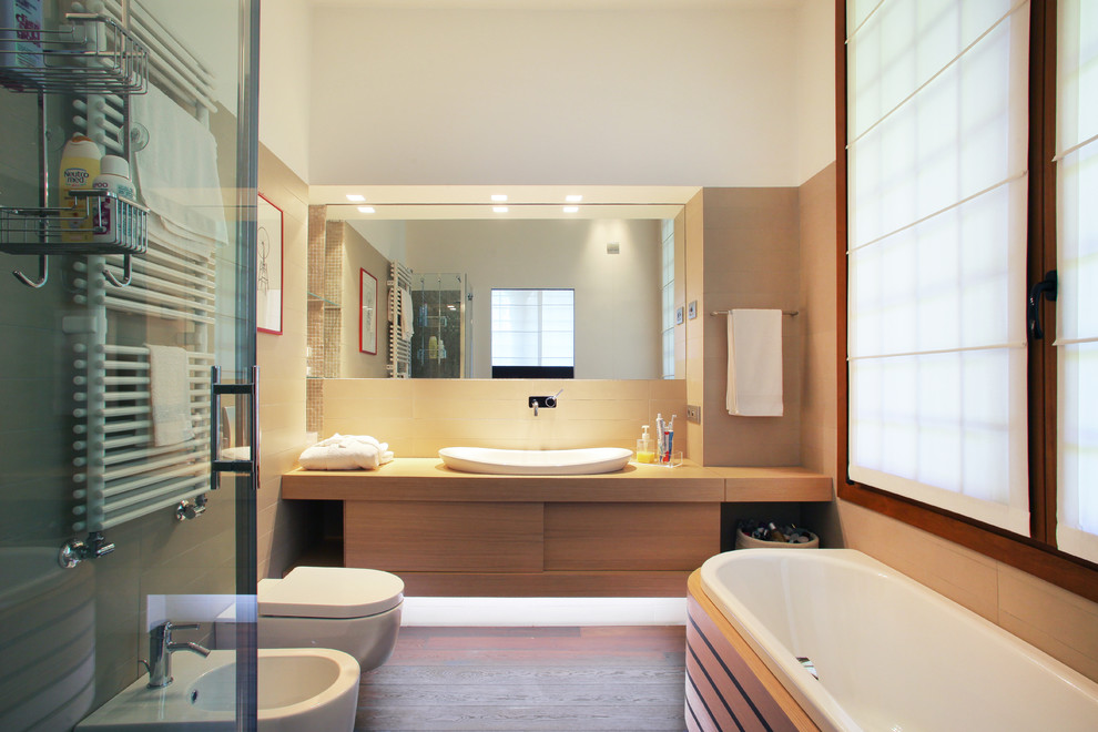 Cette photo montre une salle de bain principale tendance en bois clair avec un placard à porte plane, une baignoire posée, un mur blanc, parquet foncé, une vasque, un plan de toilette en bois et un plan de toilette beige.
