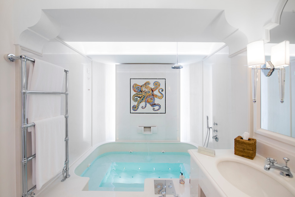 Foto di una grande stanza da bagno mediterranea con lavabo sottopiano, vasca idromassaggio, vasca/doccia, pareti bianche, ante bianche e piastrelle bianche
