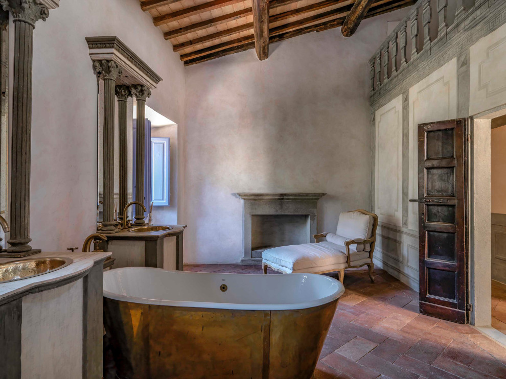Mediterranean bathroom in Florence with a freestanding bath, grey walls, a built-in sink, red floors, white worktops, double sinks, a built in vanity unit, exposed beams, a vaulted ceiling and a wood ceiling.