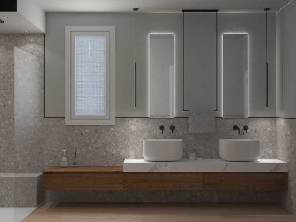 Modern inredning av ett stort badrum med dusch, med släta luckor, skåp i ljust trä, en öppen dusch, en toalettstol med separat cisternkåpa, grå kakel, porslinskakel, grå väggar, ett fristående handfat, beiget golv och med dusch som är öppen
