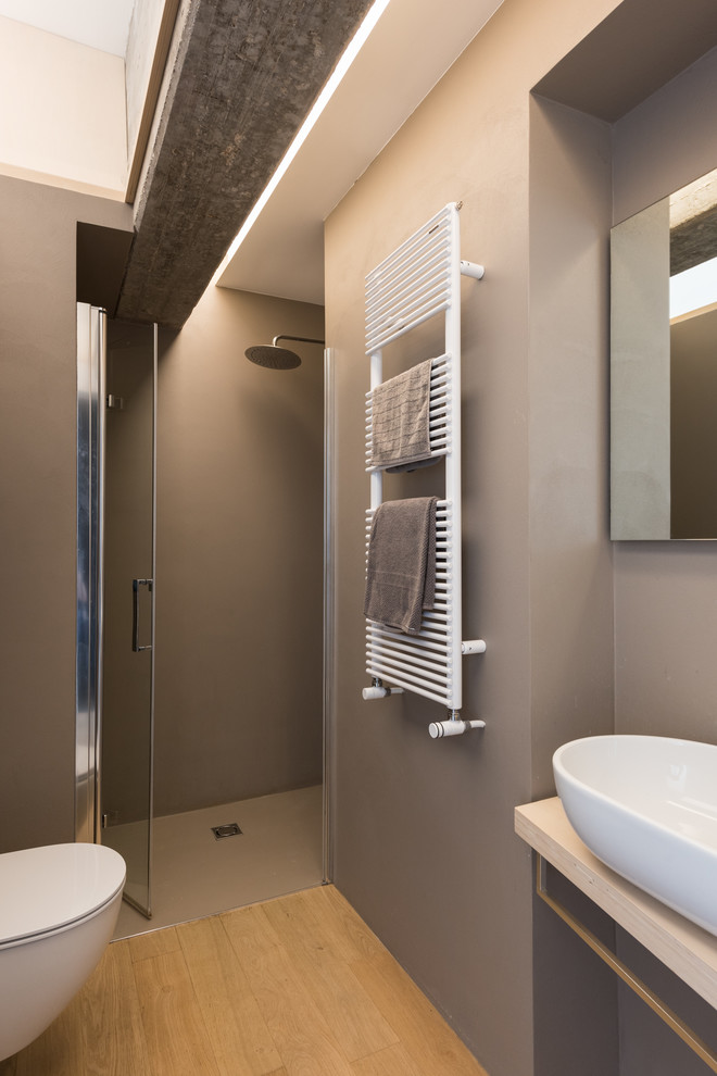 Cette image montre une salle d'eau minimaliste en bois clair avec une douche à l'italienne, un mur gris, parquet clair, un plan de toilette en bois et une cabine de douche à porte battante.