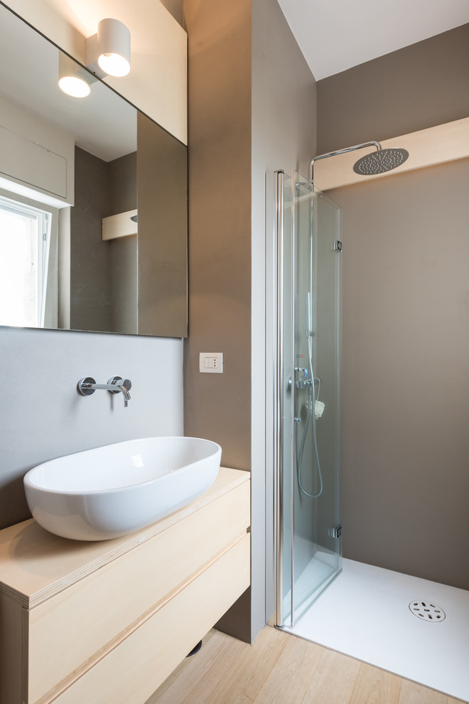 Modern inredning av ett litet beige beige badrum med dusch, med skåp i ljust trä, en kantlös dusch, grå väggar, ljust trägolv, träbänkskiva, dusch med gångjärnsdörr, släta luckor, ett fristående handfat och beiget golv