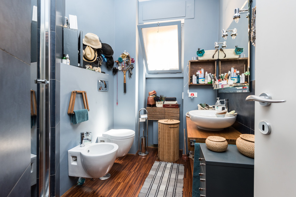 Immagine di una stanza da bagno con doccia boho chic con lavabo a bacinella, ante blu, doccia ad angolo, bidè e pareti blu