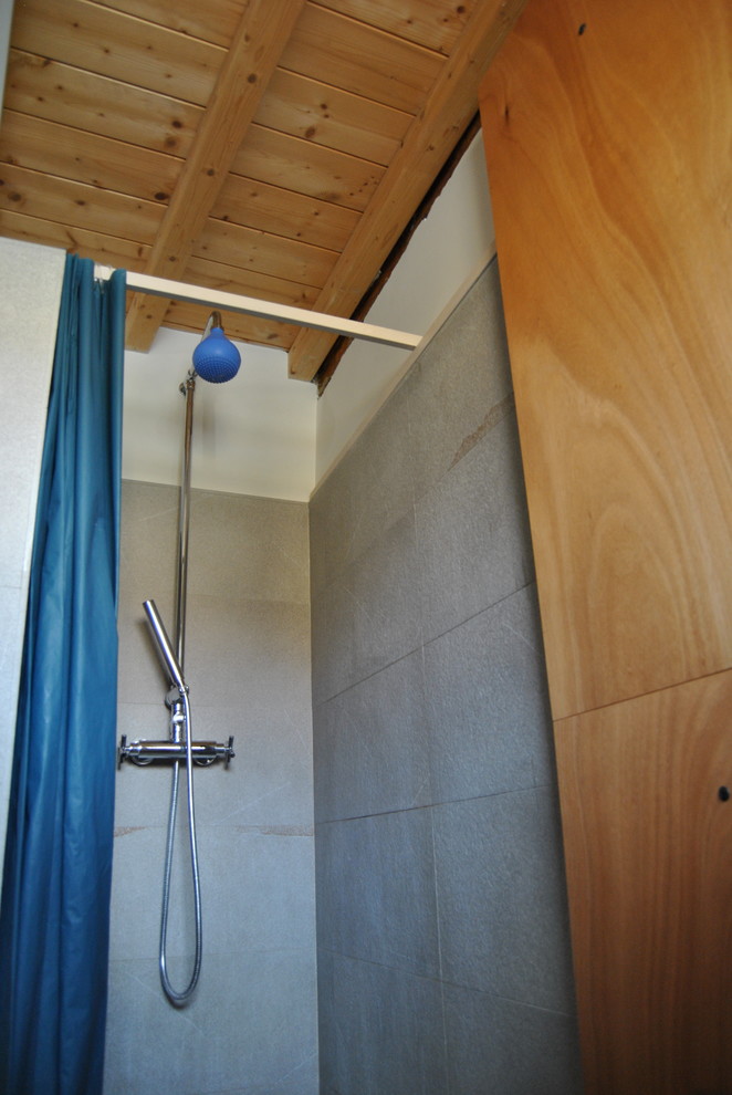 Kleines Modernes Duschbad mit Glasfronten, weißen Schränken, Eckdusche, Wandtoilette mit Spülkasten, grauen Fliesen, Porzellanfliesen, bunten Wänden, hellem Holzboden, beigem Boden und Duschvorhang-Duschabtrennung in Mailand