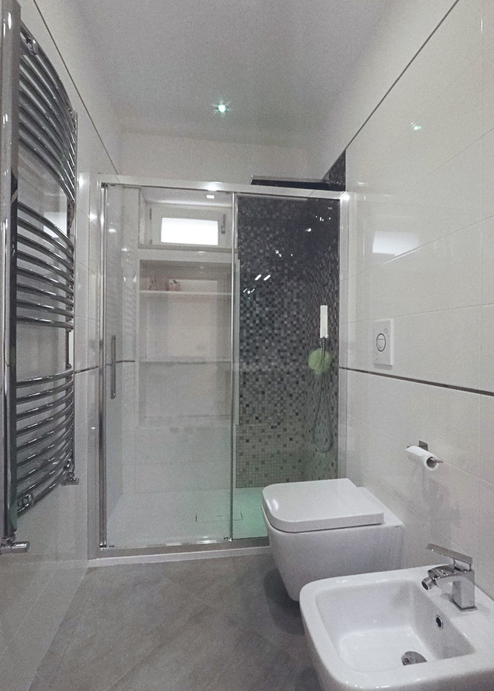 Modern inredning av ett mellanstort vit vitt badrum med dusch, med släta luckor, grå skåp, en kantlös dusch, en toalettstol med separat cisternkåpa, vit kakel, porslinskakel, vita väggar, klinkergolv i porslin, ett integrerad handfat, bänkskiva i akrylsten, grått golv och dusch med skjutdörr