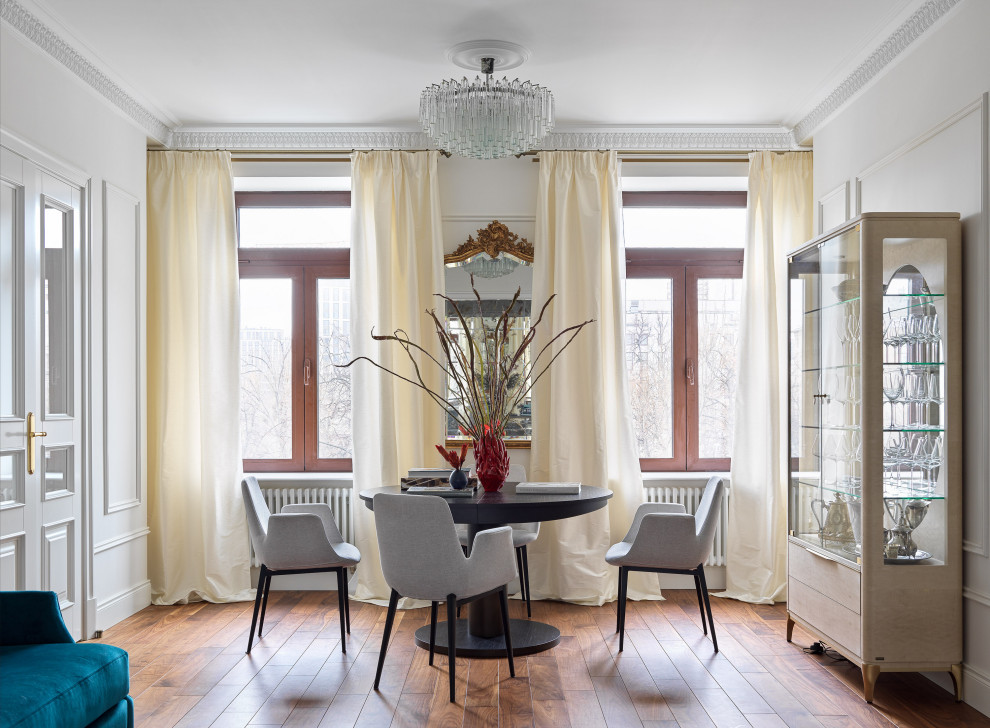 Photo of a classic dining room in Moscow with white walls, medium hardwood flooring, brown floors and panelled walls.