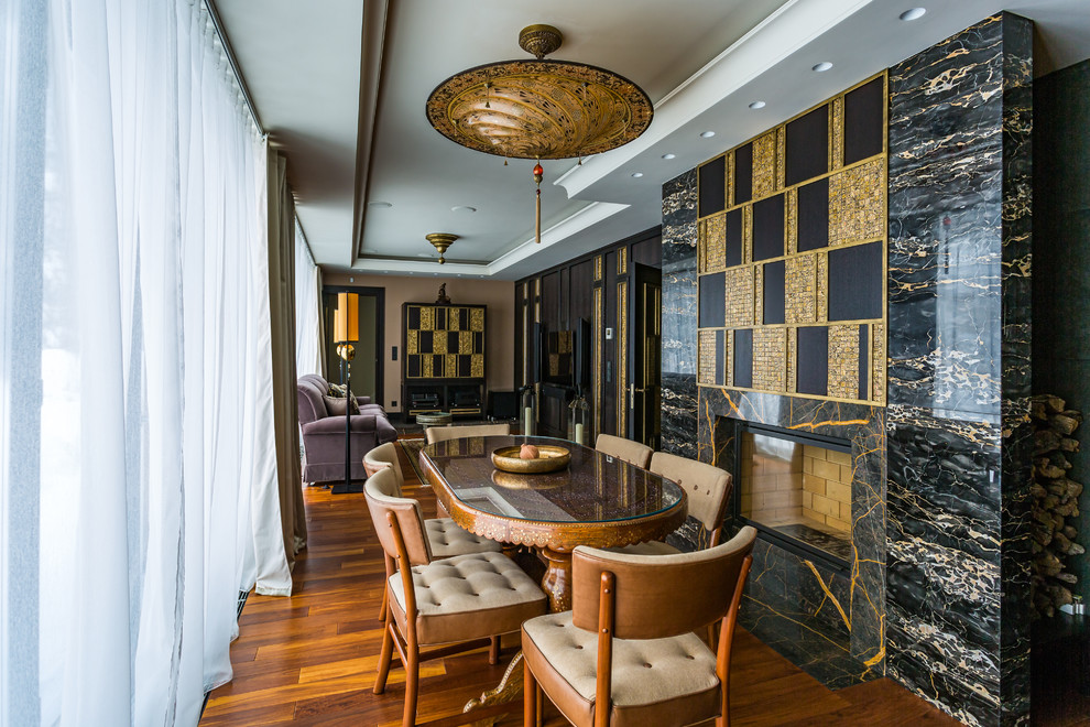 Стильный дизайн: гостиная-столовая в классическом стиле с коричневыми стенами, паркетным полом среднего тона, стандартным камином и коричневым полом - последний тренд