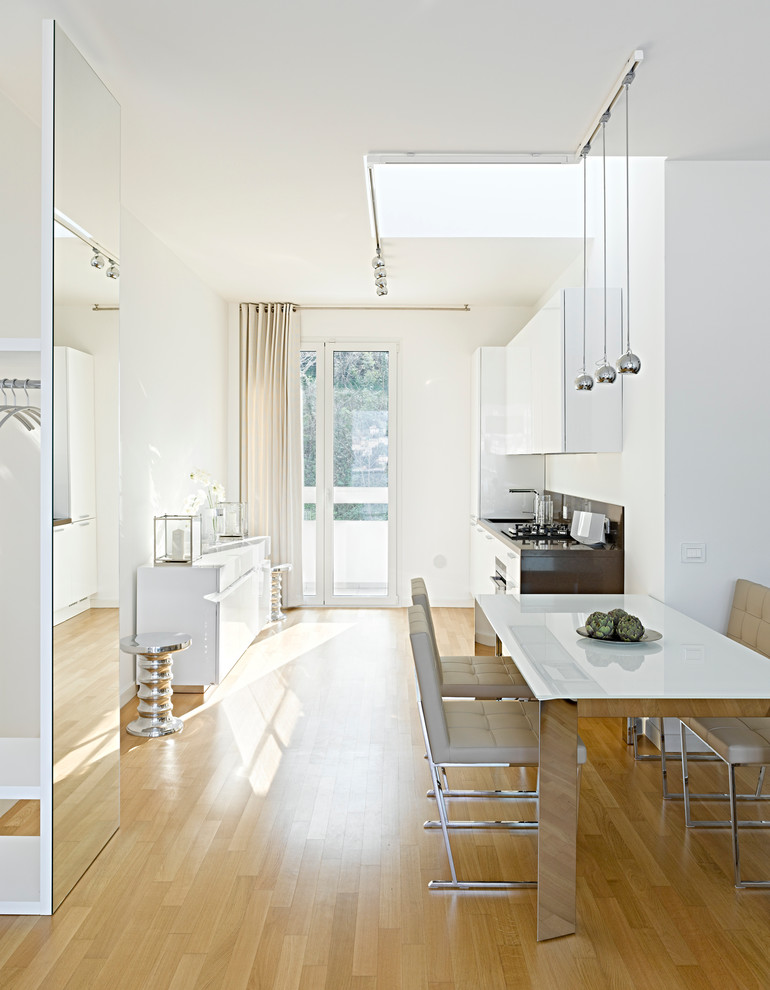 На фото: большая кухня-столовая в современном стиле с белыми стенами и светлым паркетным полом с