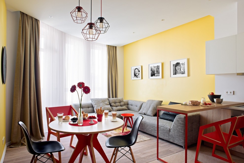 Diseño de comedor contemporáneo abierto con paredes amarillas