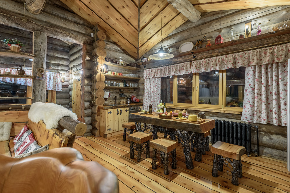 Exemple d'une salle à manger ouverte sur le salon montagne avec un mur marron, un sol en bois brun et un sol marron.