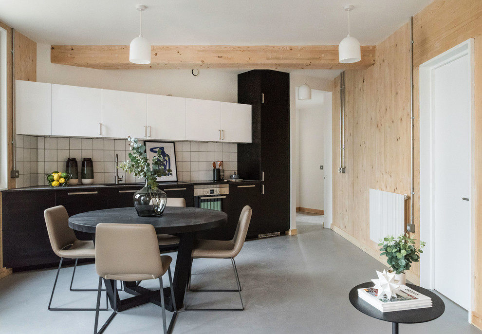 Inspiration pour une salle à manger ouverte sur la cuisine nordique de taille moyenne avec sol en béton ciré, un sol gris et un mur blanc.