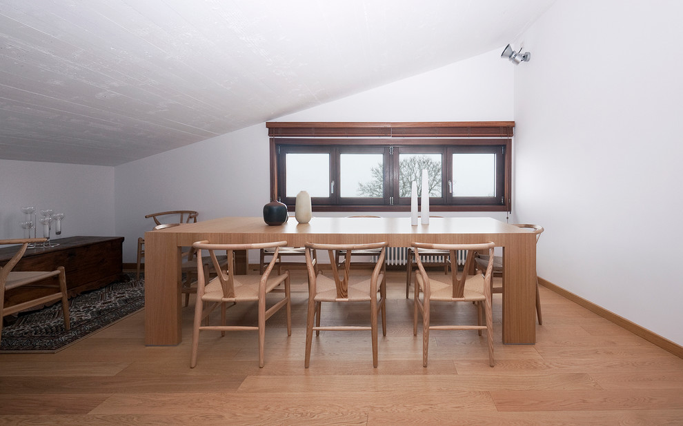 Immagine di una grande sala da pranzo minimal con pareti bianche e pavimento in legno massello medio