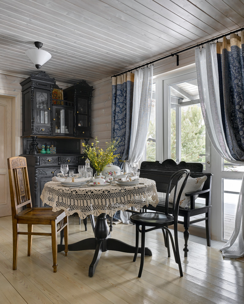Inspiration for a rural dining room in Moscow with light hardwood flooring.