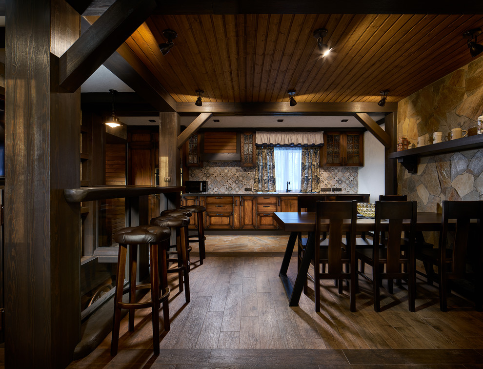 Esempio di una piccola sala da pranzo aperta verso la cucina country con pareti marroni, pavimento in legno massello medio, nessun camino e pavimento marrone
