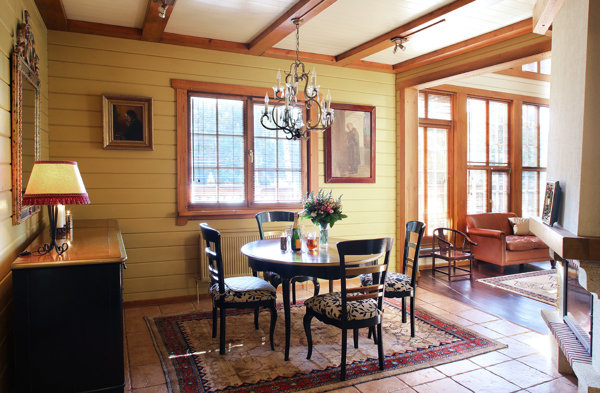 Réalisation d'une salle à manger ouverte sur le salon champêtre de taille moyenne avec un mur beige, un sol en carrelage de céramique, une cheminée d'angle, un manteau de cheminée en plâtre et un sol beige.