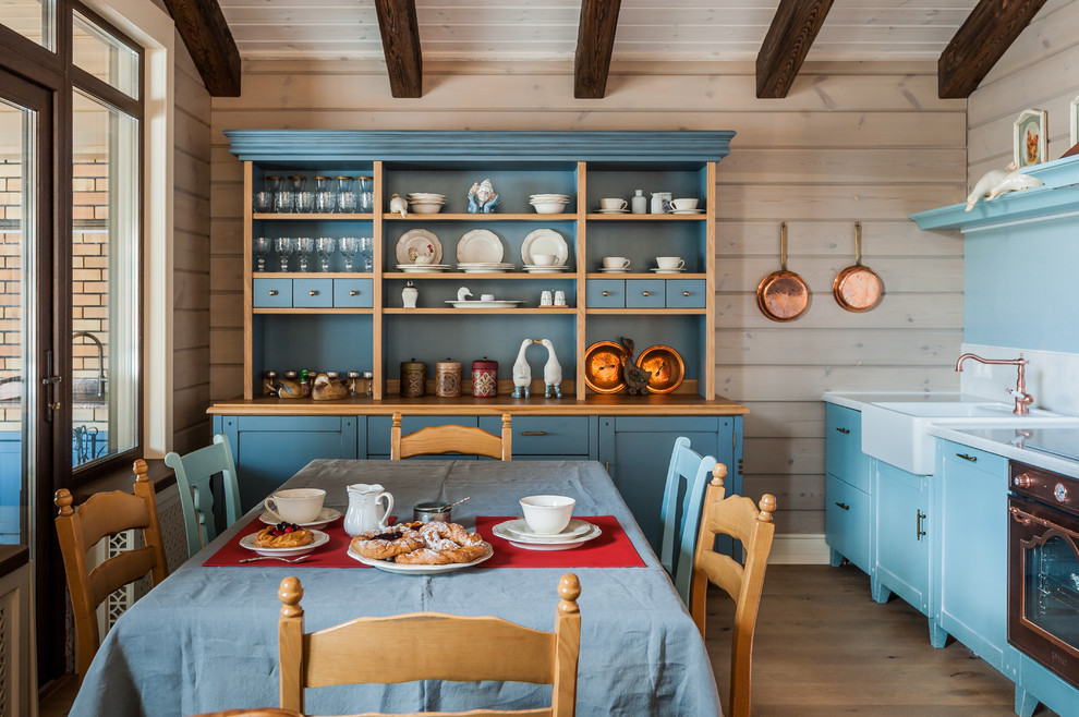 Bild på ett mellanstort lantligt kök med matplats, med beige väggar, ljust trägolv, beiget golv, en öppen hörnspis och en spiselkrans i sten
