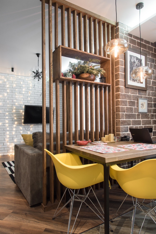 Cette image montre une salle à manger ouverte sur le salon design avec un sol marron, parquet foncé, aucune cheminée et éclairage.