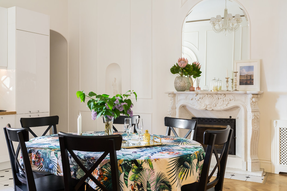Esempio di una sala da pranzo tropicale di medie dimensioni con pareti bianche, camino classico, cornice del camino in pietra, parquet chiaro e pavimento beige