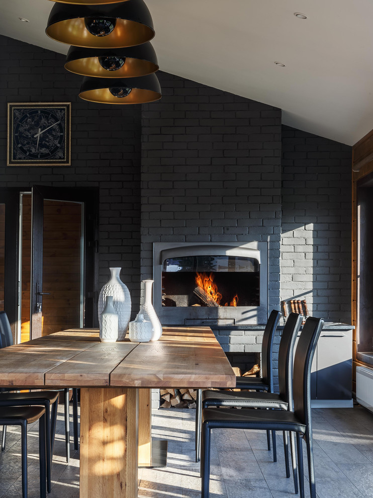 Idee per una sala da pranzo tradizionale di medie dimensioni con pavimento grigio, pareti nere e stufa a legna