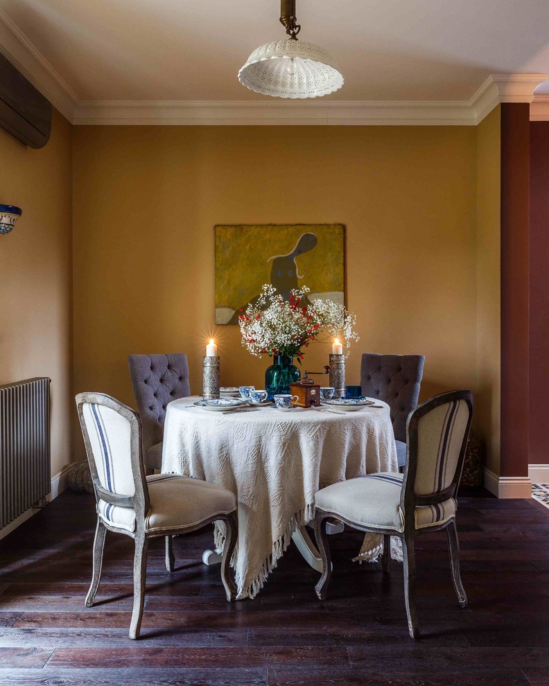 Ispirazione per una sala da pranzo aperta verso la cucina boho chic di medie dimensioni con parquet scuro e pareti gialle