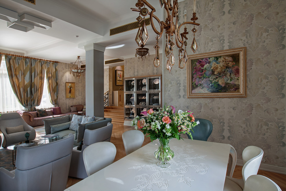 Idée de décoration pour une grande salle à manger ouverte sur le salon avec un mur gris et un sol en bois brun.