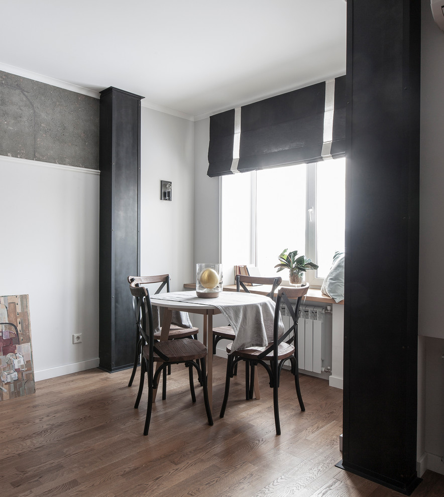 Immagine di una piccola sala da pranzo aperta verso il soggiorno minimal con pareti bianche, pavimento in legno massello medio e pavimento marrone