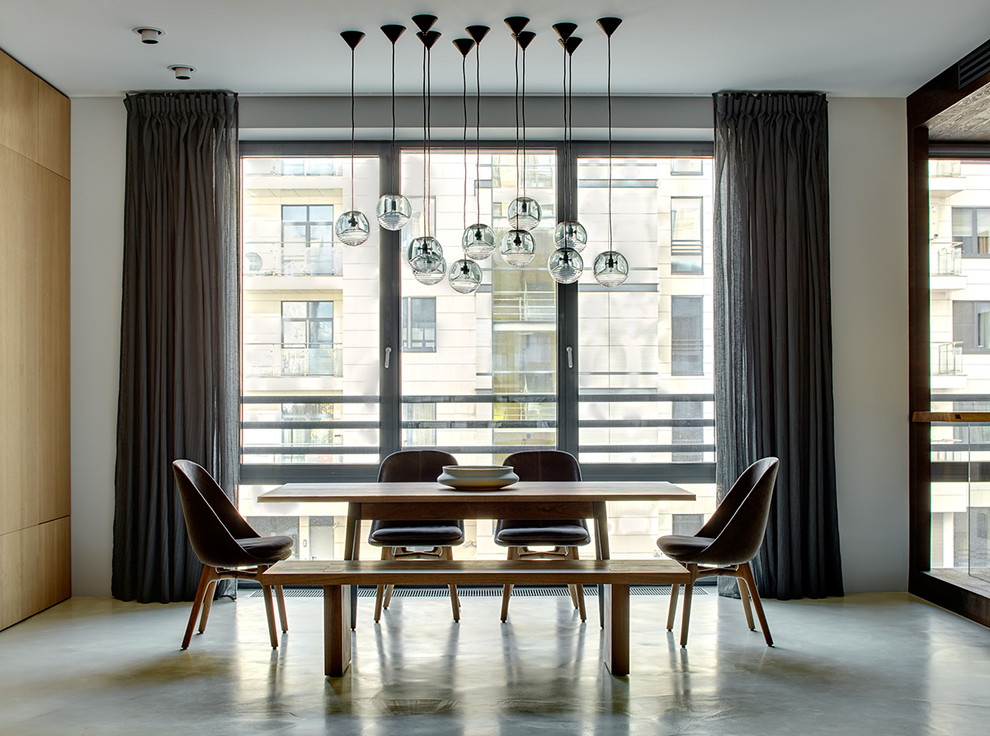 Стильный дизайн: большая гостиная-столовая в современном стиле с бетонным полом, серым полом и белыми стенами - последний тренд