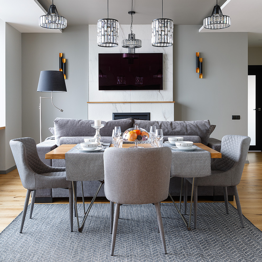 Immagine di una sala da pranzo aperta verso il soggiorno minimal con pareti grigie, pavimento in legno massello medio e pavimento marrone