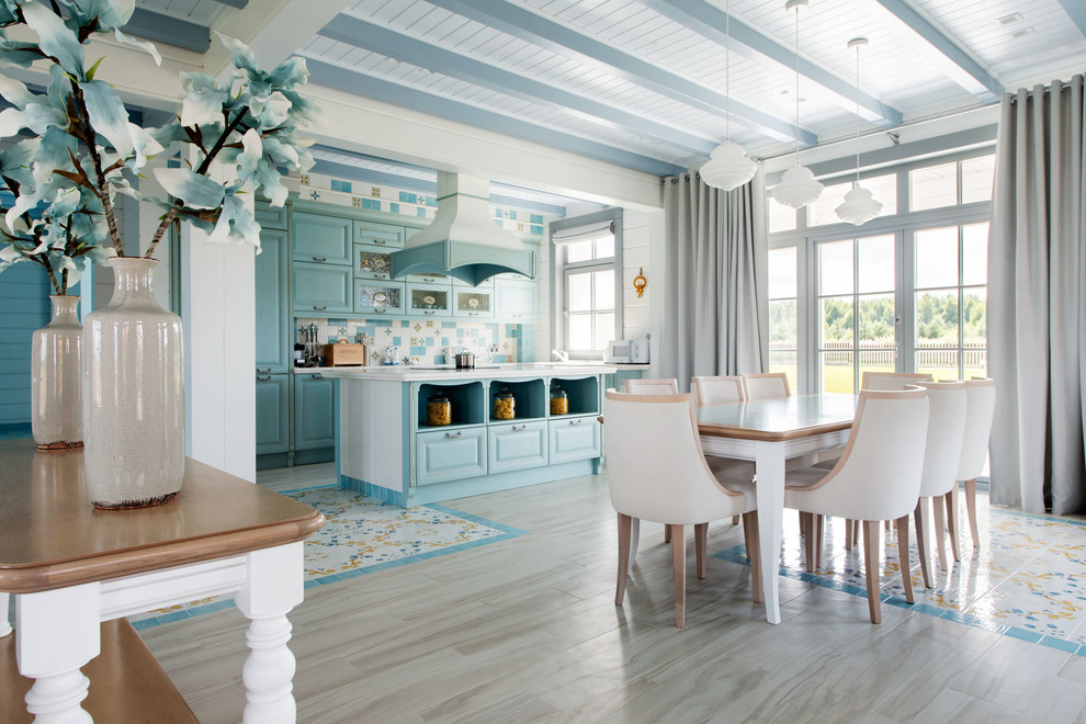 Immagine di una sala da pranzo aperta verso il soggiorno mediterranea con pareti bianche e pavimento multicolore