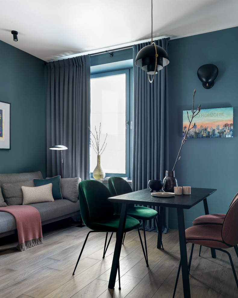 Idées déco pour une petite salle à manger contemporaine avec un sol en bois brun, un sol marron et un mur bleu.