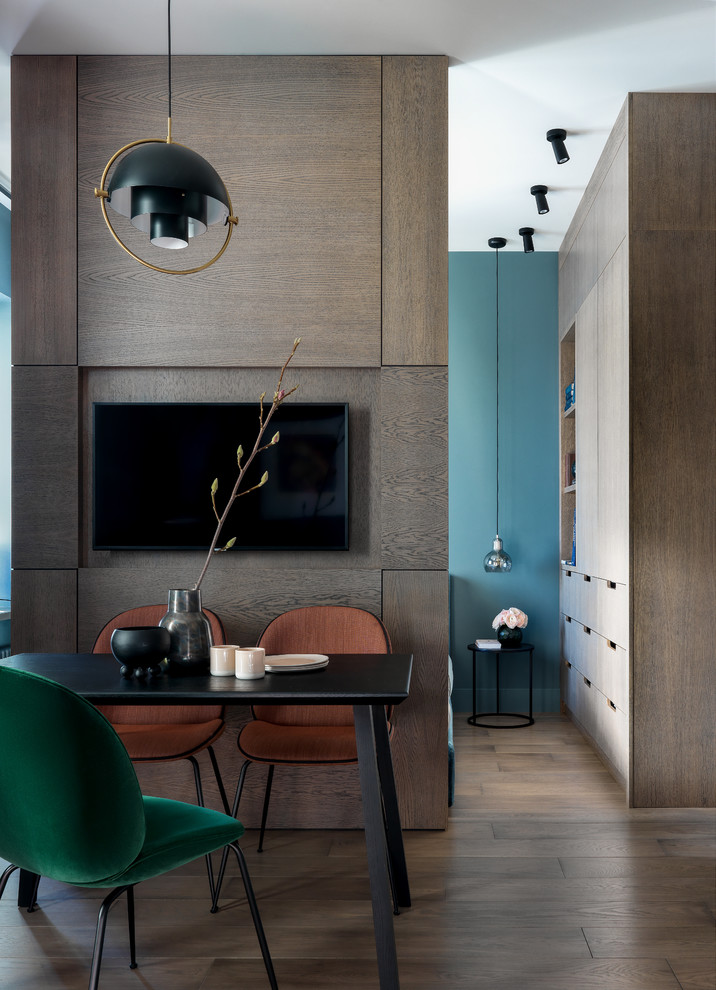 Идея дизайна: маленькая гостиная-столовая в современном стиле с синими стенами, паркетным полом среднего тона и коричневым полом для на участке и в саду