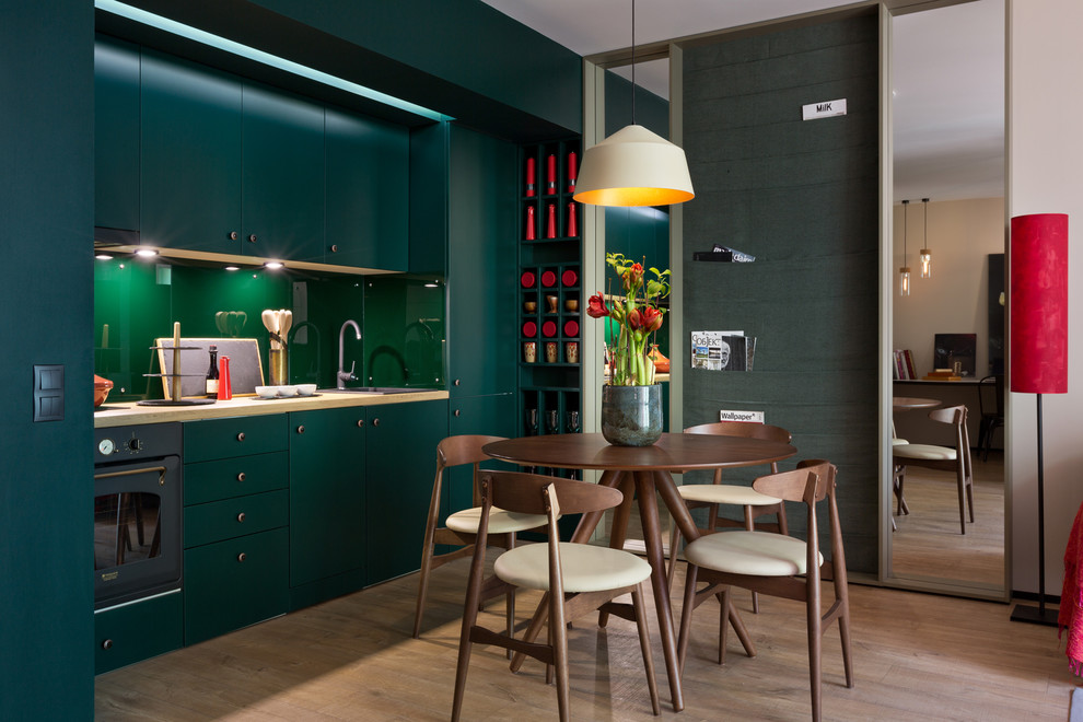 Kleine Moderne Wohnküche mit grüner Wandfarbe, braunem Holzboden und braunem Boden in Sonstige