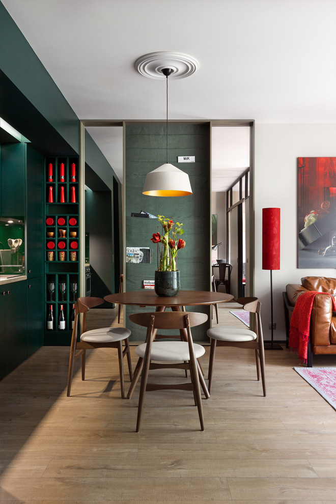 Immagine di una piccola sala da pranzo aperta verso la cucina minimal con pareti verdi
