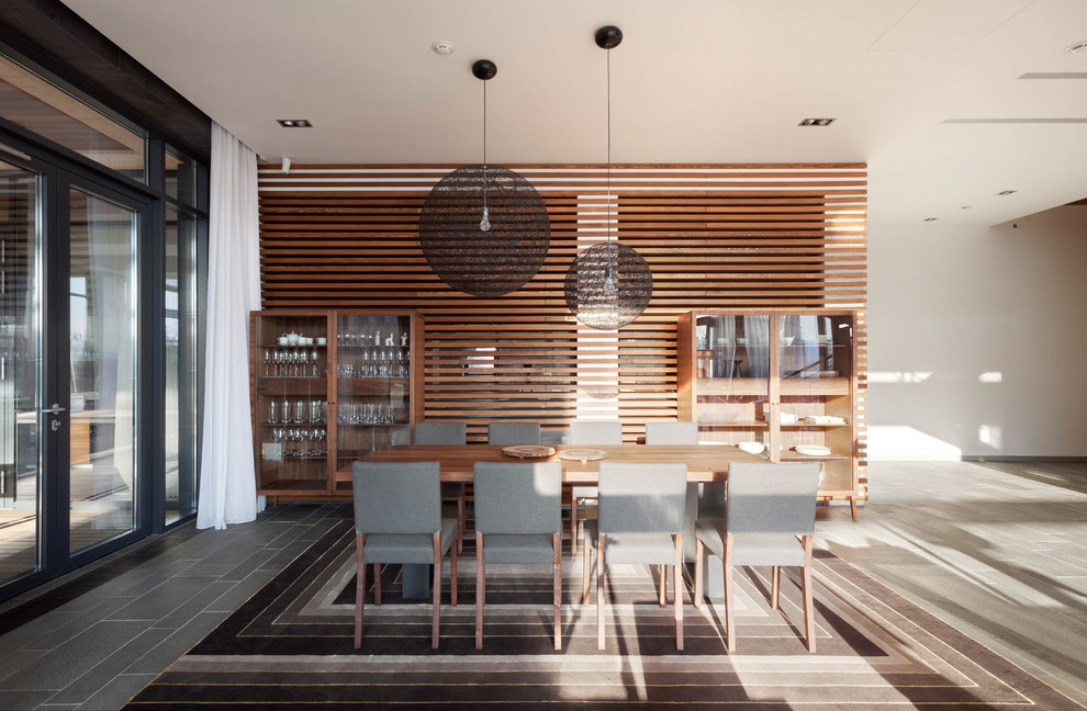 Стильный дизайн: большая гостиная-столовая в современном стиле с полом из сланца, серым полом и белыми стенами - последний тренд