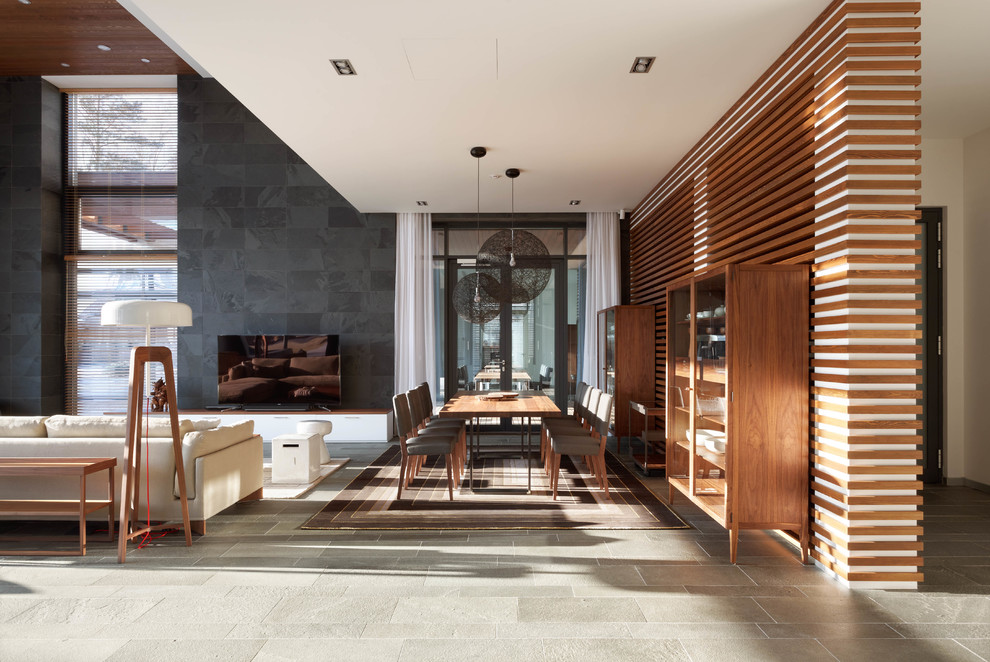 Idee per una grande sala da pranzo aperta verso il soggiorno minimal con pareti multicolore, pavimento in ardesia e pavimento grigio