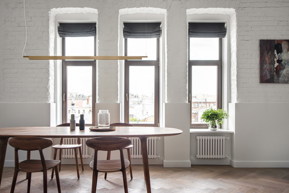 Foto di una sala da pranzo aperta verso il soggiorno minimal di medie dimensioni con pareti bianche, pavimento in legno massello medio, pavimento marrone e travi a vista