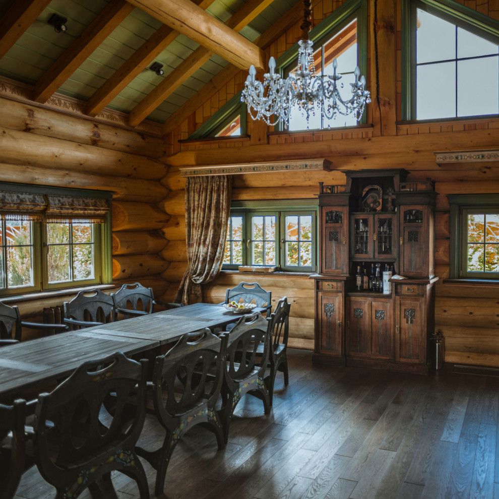 Aménagement d'une salle à manger montagne avec un mur marron, parquet foncé, un sol marron, poutres apparentes, un plafond voûté et un plafond en bois.