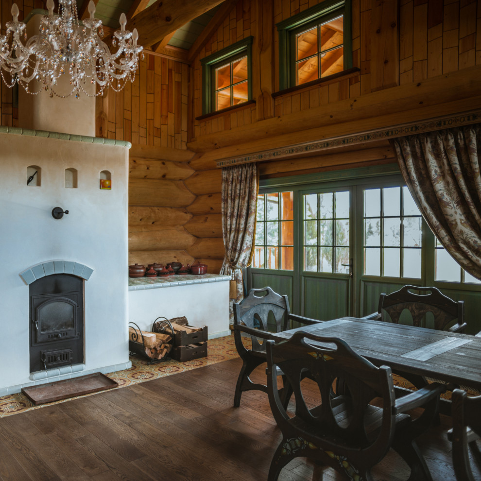 Inspiration pour une salle à manger chalet en bois avec un mur marron, un sol marron et un plafond voûté.