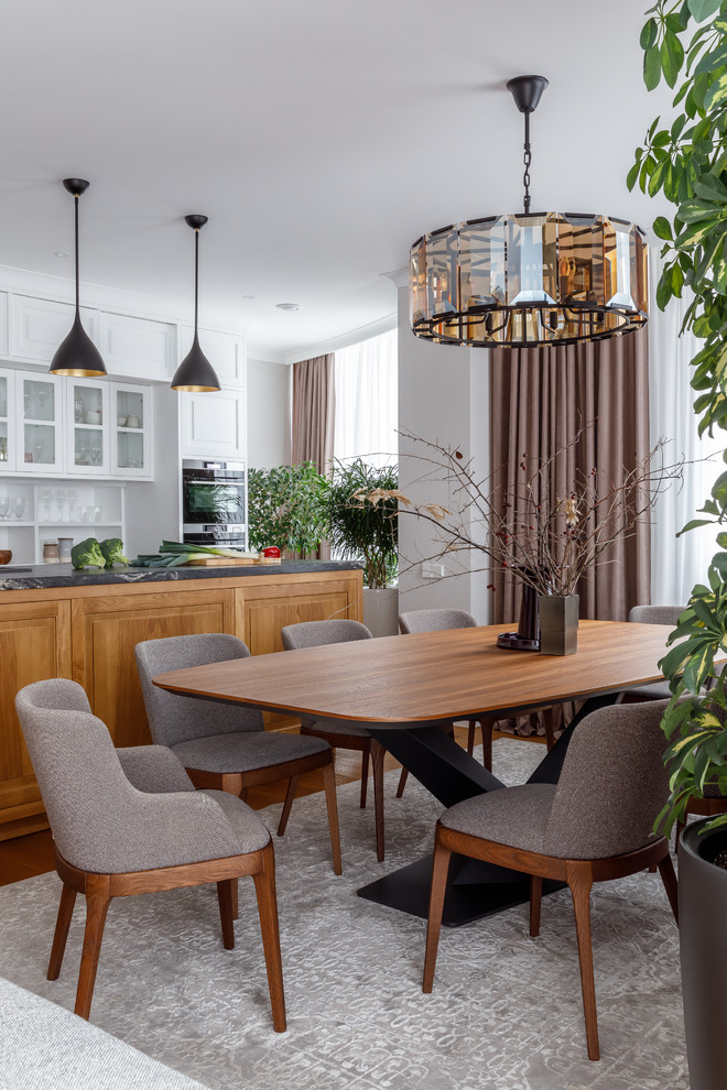 Immagine di una grande sala da pranzo aperta verso la cucina classica con pareti grigie, pavimento in legno massello medio e pavimento marrone