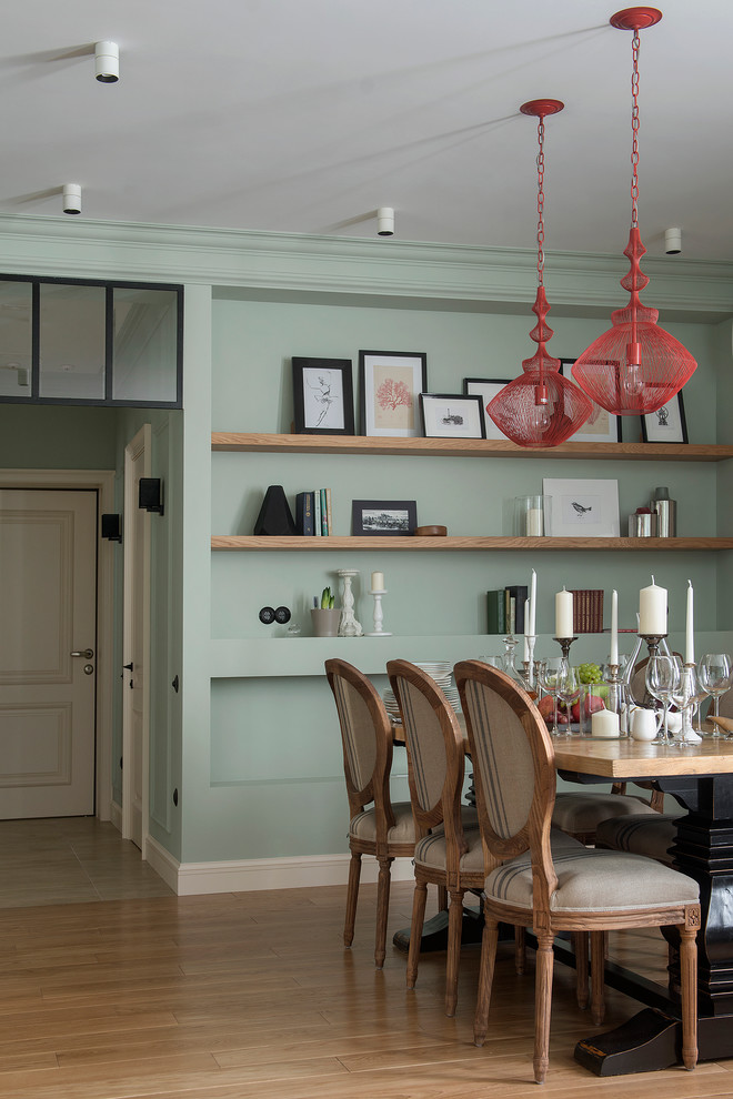Стильный дизайн: столовая в классическом стиле с светлым паркетным полом и зелеными стенами - последний тренд
